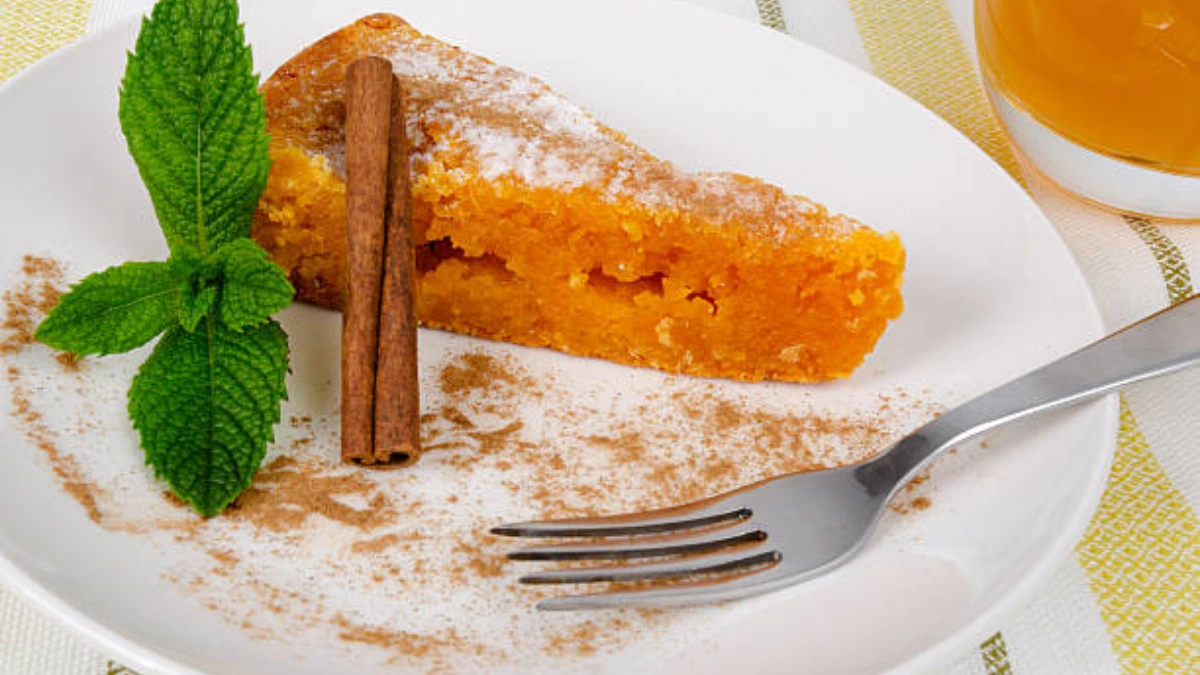 A slice of Milk Bar's Pumpkin Pie, featuring a creamy pumpkin filling with a buttery, crumbly graham cracker crust, topped with a layer of whipped cream.