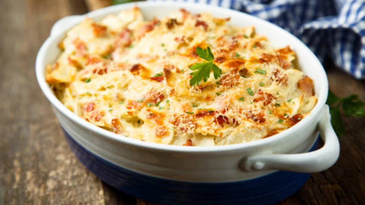 Garlic Parmesan Chicken Pasta Casserole served in a white baking dish, garnished with fresh parsley and a golden crust of melted cheese on top."