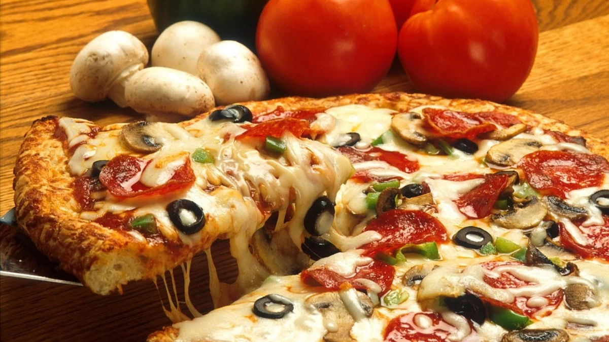 A freshly baked pizza pie with golden crust, melted cheese, and a variety of toppings including pepperoni, sausage, and vegetables.