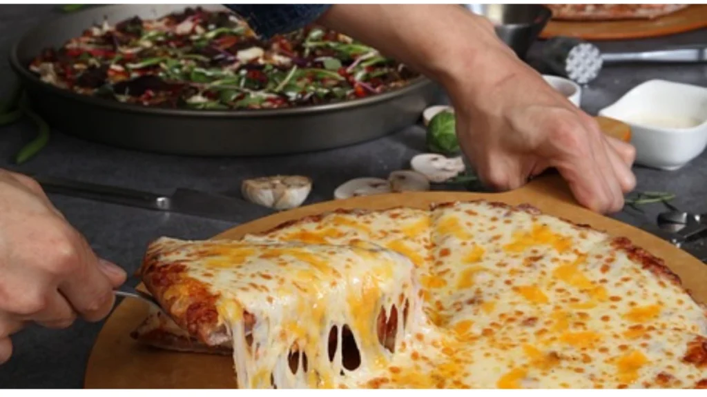 A variety of cheese options for pizza, including mozzarella, cheddar, parmesan, and blue cheese, ready to be added to a freshly made pizza.