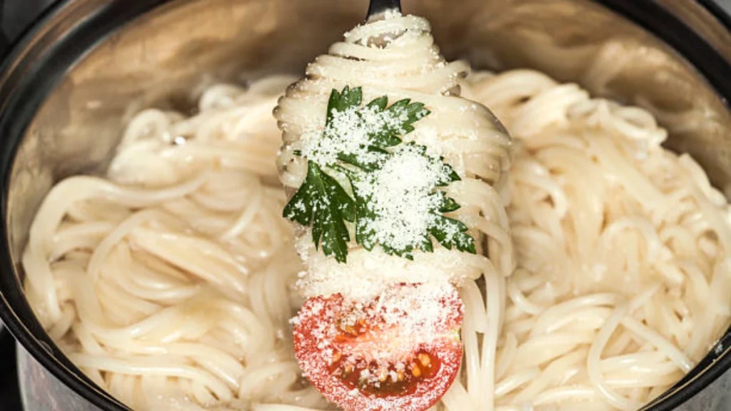 "A crock pot filled with creamy garlic parmesan chicken pasta, showcasing common issues like overcooked pasta and uneven sauce distribution to help avoid these mistakes."