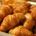 Homemade Swiss Gipfeli crescents with a golden-brown crust.